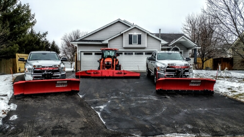 Snow plow truck clearing a driveway